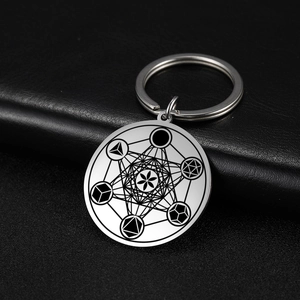 Polished stainless steel Metatron's Cube geometric keychain on black leather background
