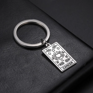 Macro view of stainless steel keychain with engraved Cancer zodiac sign and moon pattern