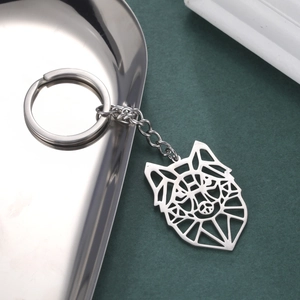 Detail of a laser-cut stainless steel wolf head keychain with minimalist geometric lines