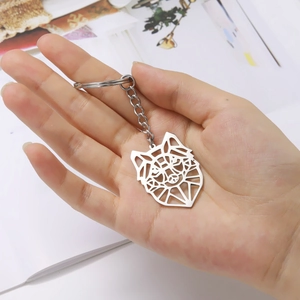 Close-up of a geometric hollow wolf head keychain in polished stainless steel finish