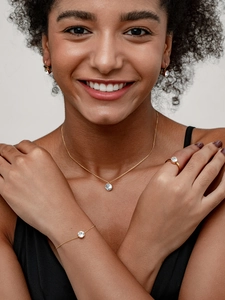 Nahaufnahme von elegantem Gold-Zirkon-Schmuckset mit Kette und Armband am weiblichen Model