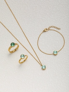 Flachbild von vergoldetem Schmuckset mit Halskette und Ringen mit grünen Edelsteinen