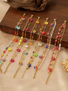 Close-up of bohemian gold-plated steel necklaces with colorful floral and heart beads
