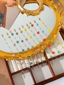 Details von bunten handgefertigten Kristallblumen auf goldenen Armbändern aus Titanstahl