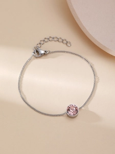 Nahaufnahme des silbernen Kettenarmbands mit einem runden rosa facettierten Kristall