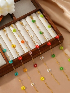 Makro-Detail bunter Perlenblumen an einem verstellbaren goldenen Gliederkettenarmband