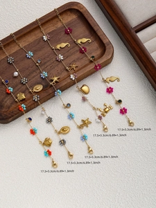 Detail of five gold ocean themed bracelets with seahorse, starfish, and colorful beads