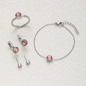 Schmuckset mit rosa Kristallen, silberner Kette, Ring und Ohrringen auf weißem Grund