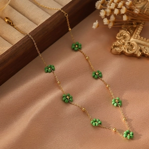 Détail d'un collier de fleurs en perles sur satin beige avec une boîte à bijoux