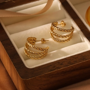 French vintage style gold triple layered twisted rope hoop earrings on white velvet