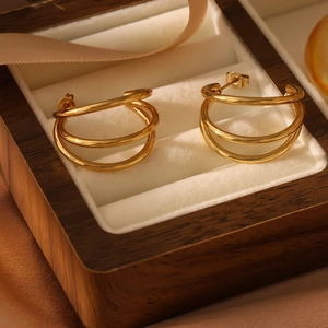 Detail of gold layered C-shaped hoop earrings inside a premium wooden jewelry box