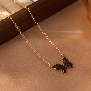 Vue détaillée d'un pendentif papillon en cristal violet avec une fine chaîne dorée