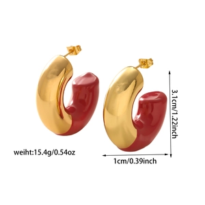 Detailed view of C-shaped hoop earrings with red enamel and gold-plated finish