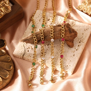 Gold-plated titanium steel bracelet with emerald and ruby-colored stones on silk