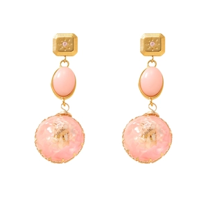 Macro view of vintage pink resin drop earrings with dried flowers and gold studs