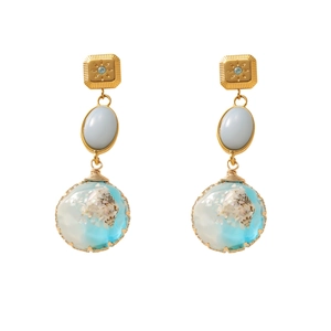 Detail of ocean-themed resin sphere earrings with shells and blue gradient inlays