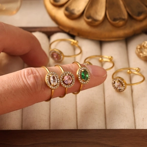 Dettaglio di anelli vintage dorati con pietre colorate di zircone e incastonatura micro-pave