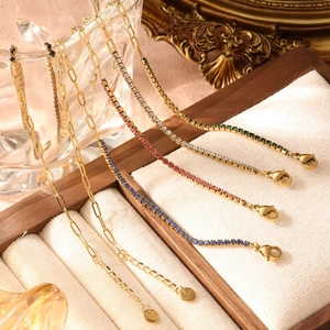 Ensemble de bracelets en acier doré avec zircons colorés sur présentoir de luxe
