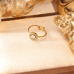Dettaglio dell'anello regolabile tonalità oro con zircone halo e pavé di piccoli diamanti