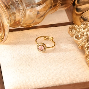 Dettaglio dell'anello a cuore dorato con zircone rosa su un piedistallo strutturato