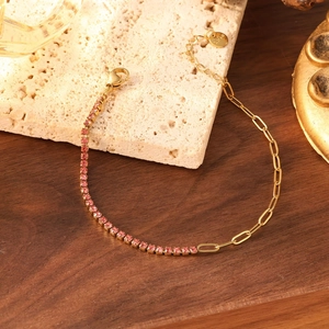 Détail macro du bracelet plaqué or avec pierres de zircon rose et étiquette en acier