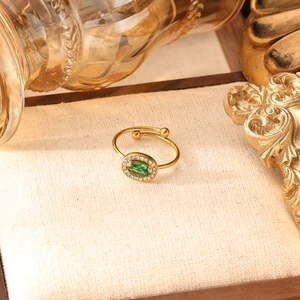 Dettaglio dell'anello regolabile dorato con zircone verde e finitura pavé di diamanti
