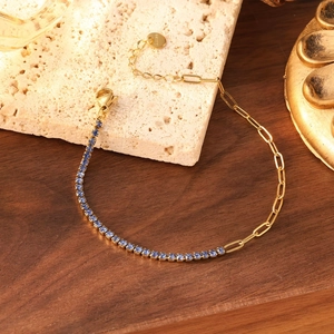 Détail du bracelet chaîne trombone dorée et tennis de zircons bleu clair sur pierre