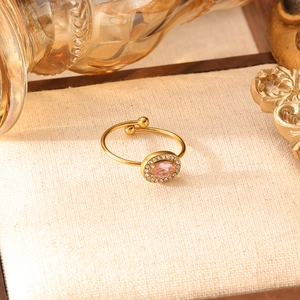 Dettaglio di un anello regolabile a cuore con zircone rosa e finitura dorata lucida