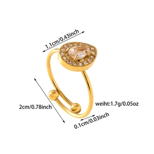 Dettaglio di un anello regolabile dorato con zircone a goccia e piccoli cristalli lucenti