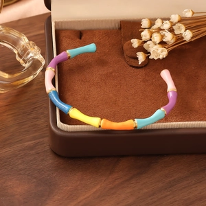 Close-up of a colorful enamel bamboo-style bracelet in a luxury jewelry box