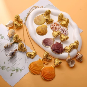 Detail of gold heart charms and natural seashells on necklace and earrings set