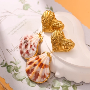Detailed close-up of shell drop earrings with gold heart studs and natural scallop texture