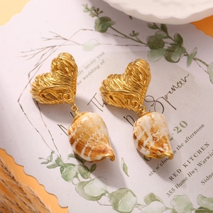 French vintage gold heart earrings with natural conch pendants on an invitation card