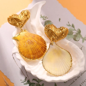 Detailed close-up of heart-shaped gold studs and natural seashell pendants with gilded edges