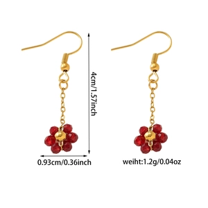 Détail de boucles d'oreilles bohèmes en perles de cristal rouge avec crochets dorés