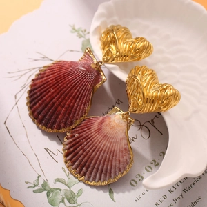 Detailed close-up of heart seashell earrings with gold edges and purple natural texture