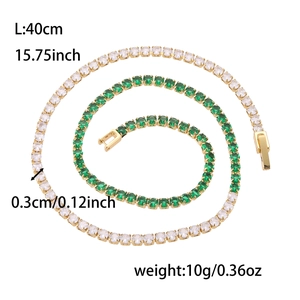 Détail macro de la chaîne tennis dorée avec des pierres de zircon blanc et vert