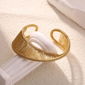 Detailed view of the gold-toned plum blossom branch cuff bracelet with textured wire finish