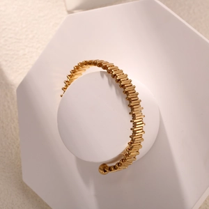 Golden open cuff bracelet with plum blossom branch design and textured metal finish