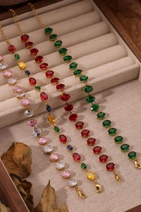 Détails de quatre bracelets tennis en cristal coloré présentés sur un plateau en velours