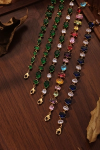Détail macro de bracelets de luxe dorés sertis de zircons de différentes couleurs