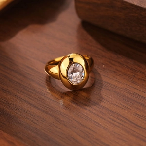 Détail d'une bague vintage plaquée or avec un zircon ovale serti sur une surface en bois