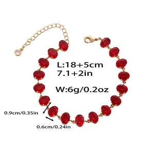 Détail d'un bracelet en chaîne dorée avec zircons rouges et spécifications de taille
