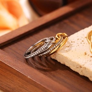 Dettaglio macro di tre anelli intrecciati con placcatura in argento e oro e pietre pavé