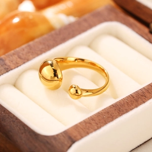 Dettaglio ravvicinato di un anello regolabile placcato oro 18K con sfere su scatola in legno