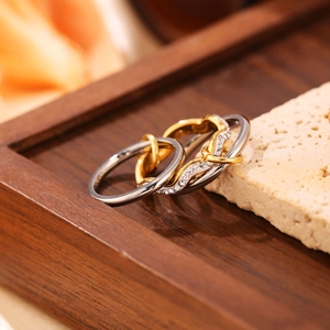 Dettaglio di anelli a strati con fasce d'argento e nodo d'oro con pietre pavé incastonate