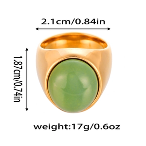 Détail d'une large bague en acier titane doré ornée d'une grande pierre naturelle verte