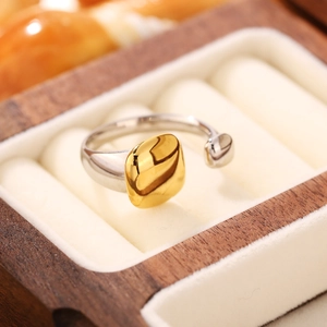Dettaglio macro di anello in argento con quadrato dorato su espositore in legno