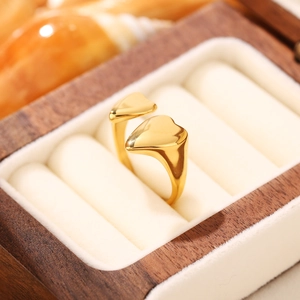 Dettaglio anello a doppio cuore dorato regolabile in una scatola portagioie elegante