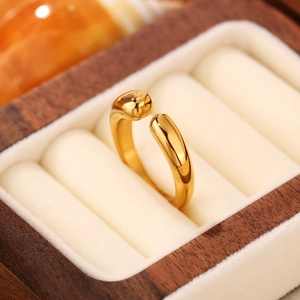 Dettaglio di un anello aperto minimalista placcato oro 18K in una scatola di legno e velluto